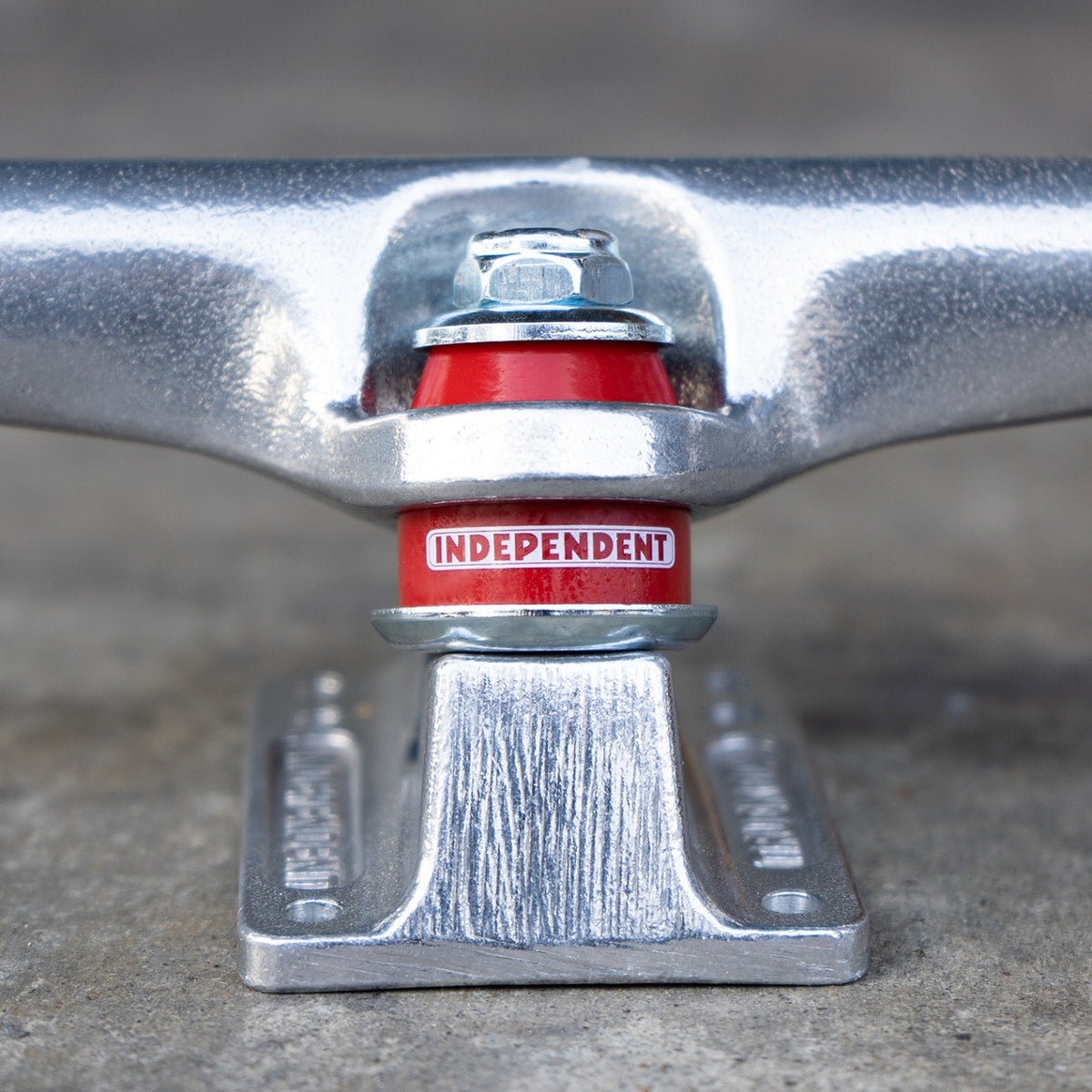 Close-up of a polished skateboard truck and red bushing